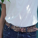 zoom sur la ceinture à boucle en raphia chinée naturel et bordeaux sur un jean 