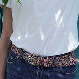 zoom sur la ceinture à boucle en raphia chinée naturel et bordeaux sur un jean 