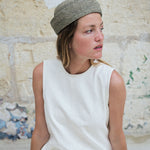 vue de profil du petit chapeau marin bleu écume en raphia porté avec une robe blanche