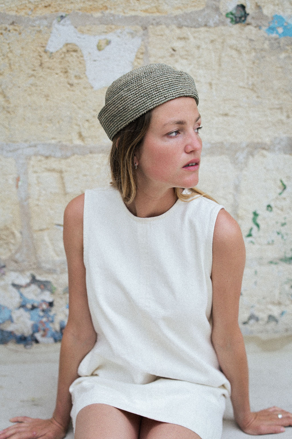 vue de profil du petit chapeau marin bleu écume en raphia porté avec une robe blanche
