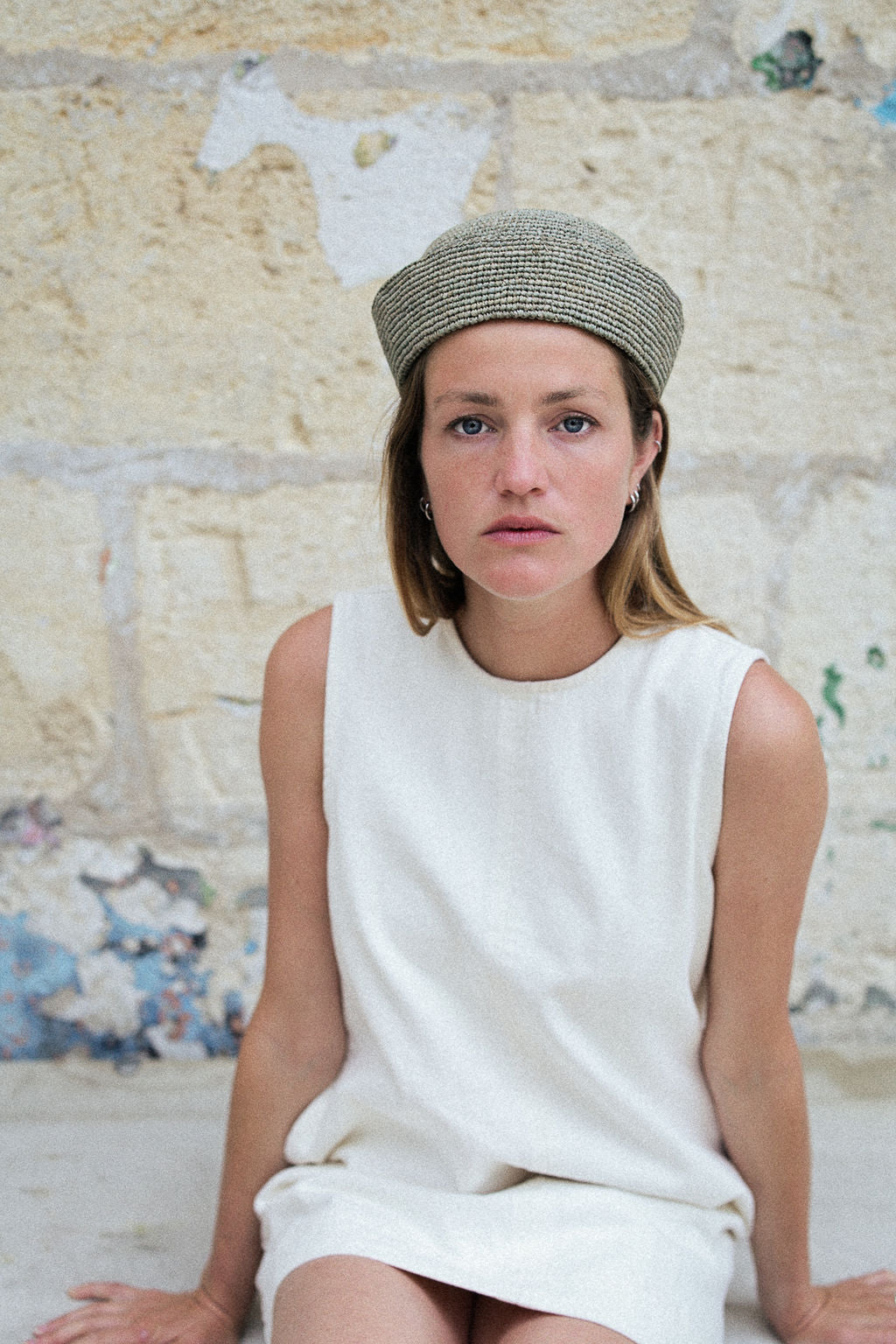 chapeau marin en raphia bleu écume porté avec une robe blanche