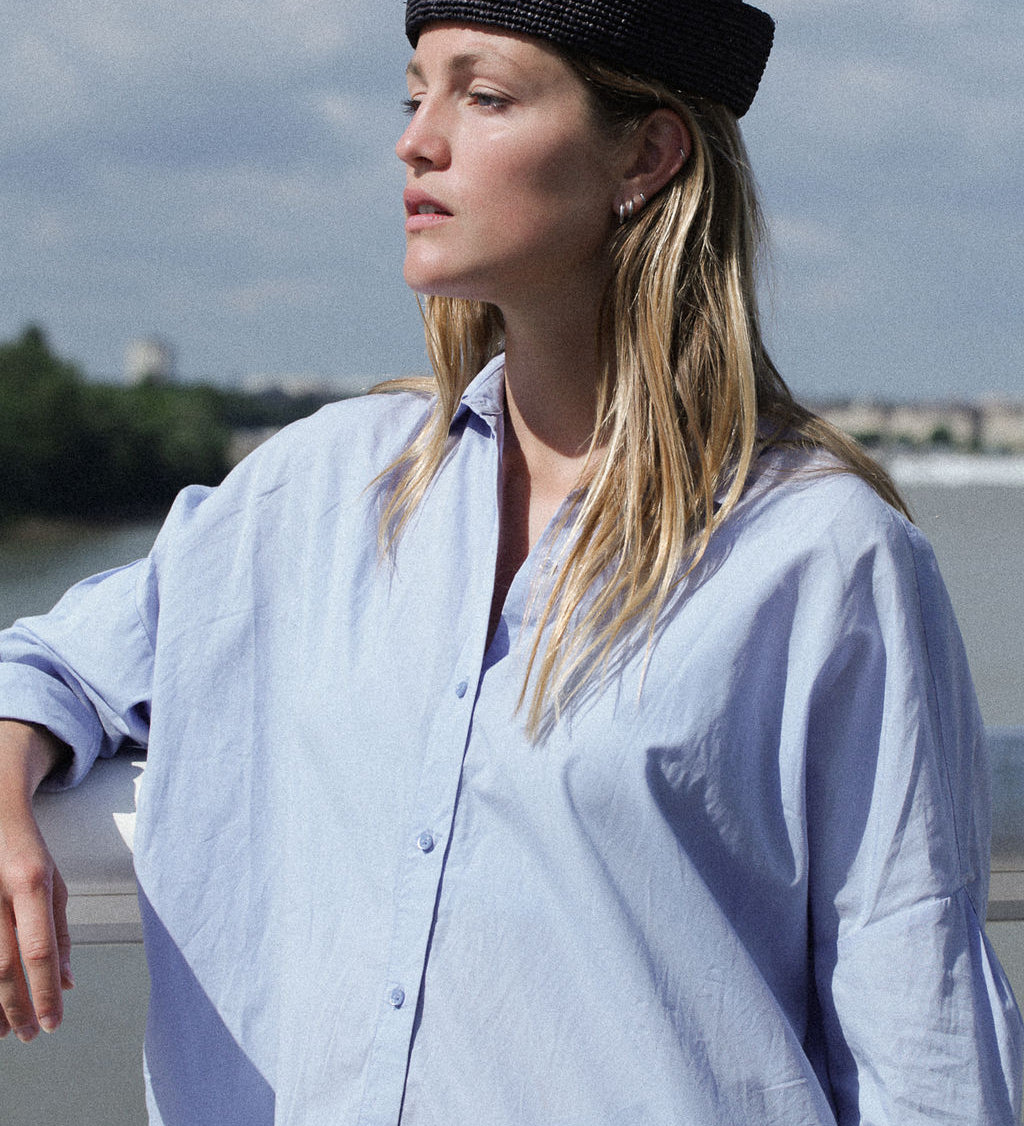 chapeau marin en crochet de raphia noir porté avec une chemise bleue
