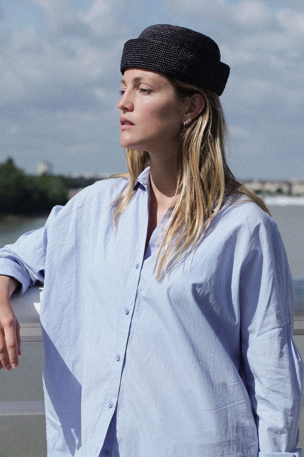 chapeau marin en crochet de raphia noir porté avec une chemise bleue