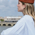 profil du petit chapeau marin en raphia sienne porté avec une tenue décontractée