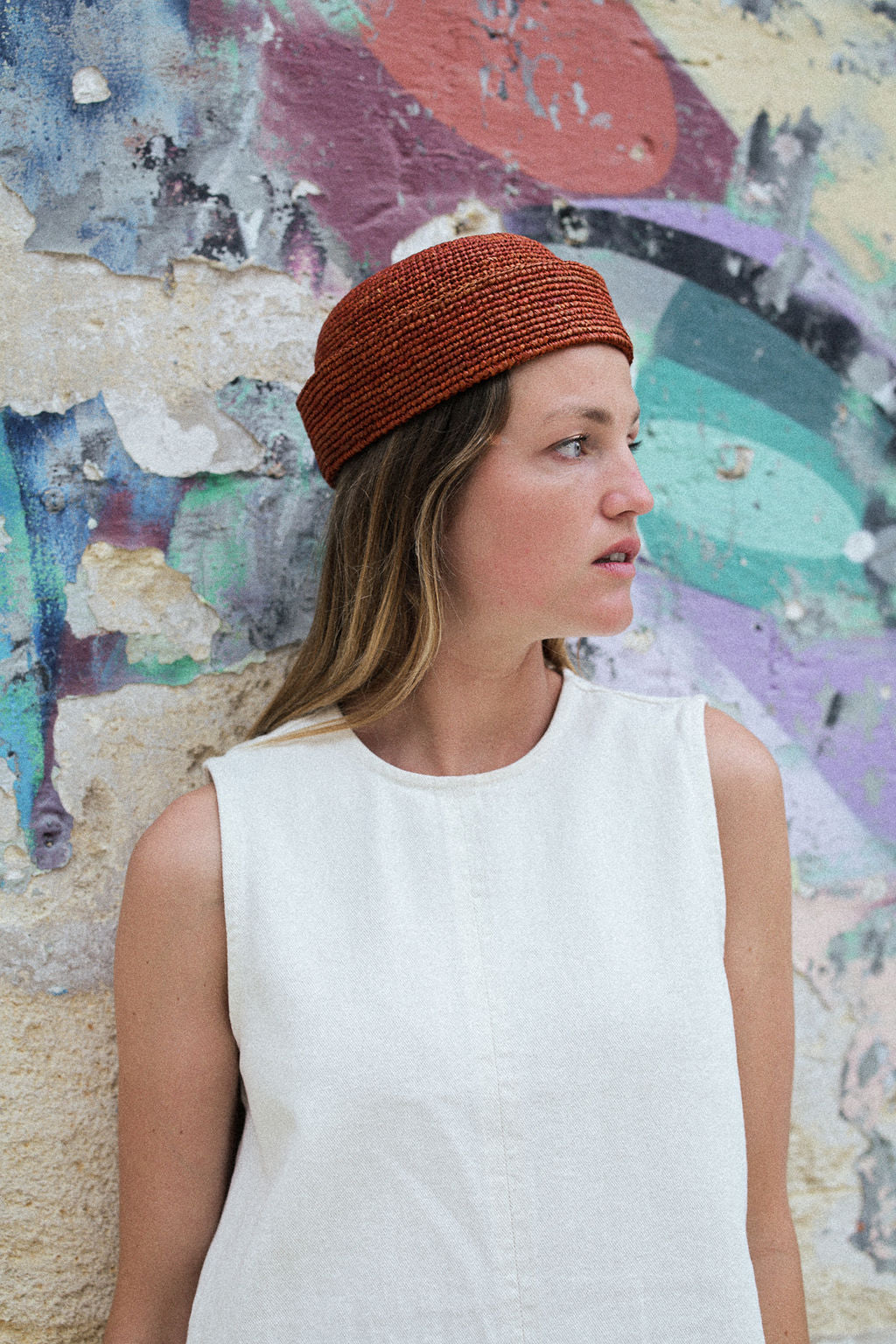 vue de profil du chapeau amrin terracotta porté avec une robe blanche