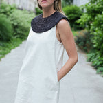col amovible noir porté en plastron sur une robe blanche 