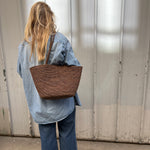 grand cabas en crochet de raphia marron porté avec une tenue décontractée