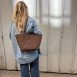 grand cabas en crochet de raphia marron porté avec une tenue décontractée