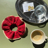 grand chouchou en raphia rouge posé sur la table d'un café