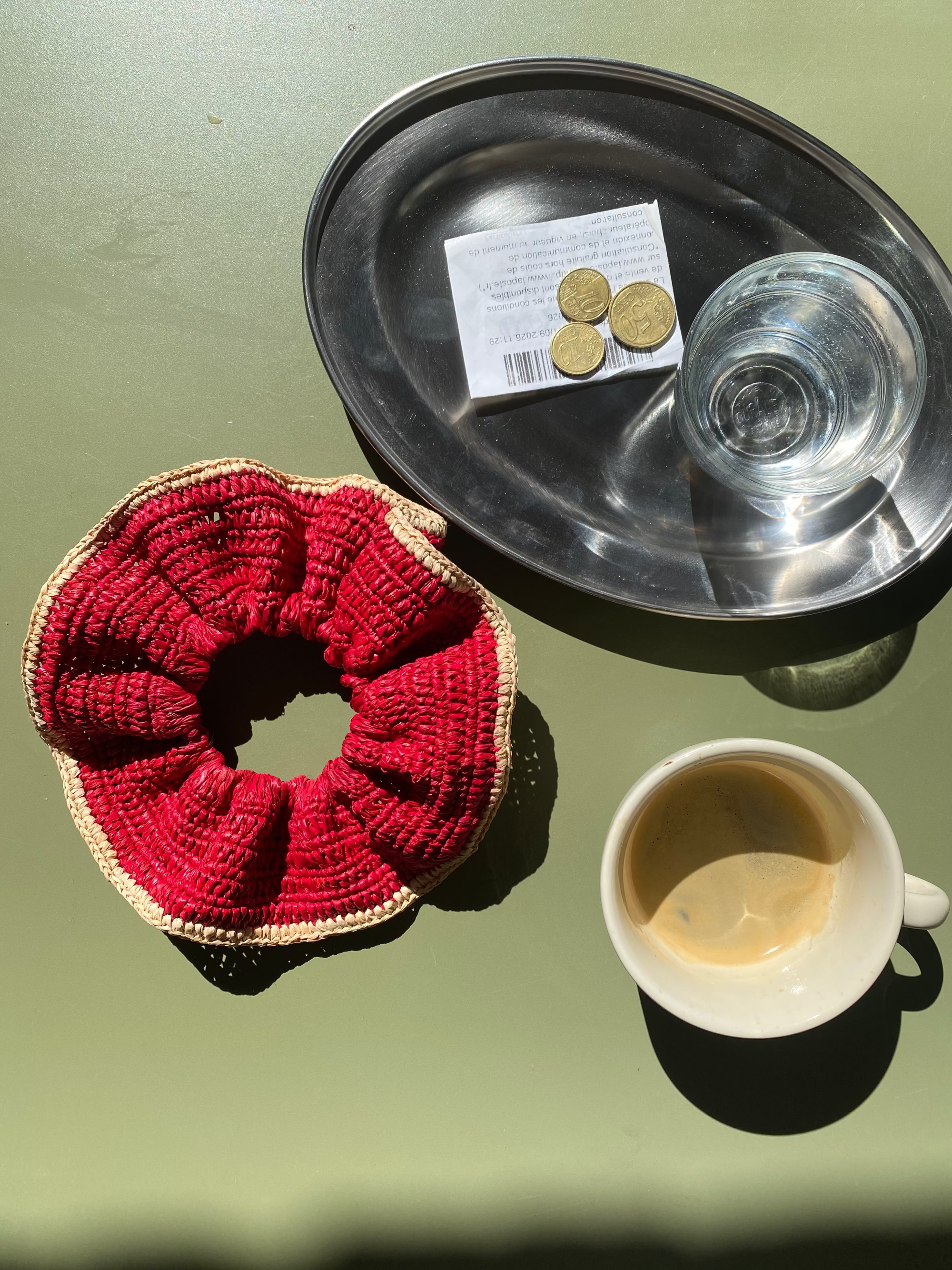 grand chouchou en raphia rouge posé sur la table d'un café