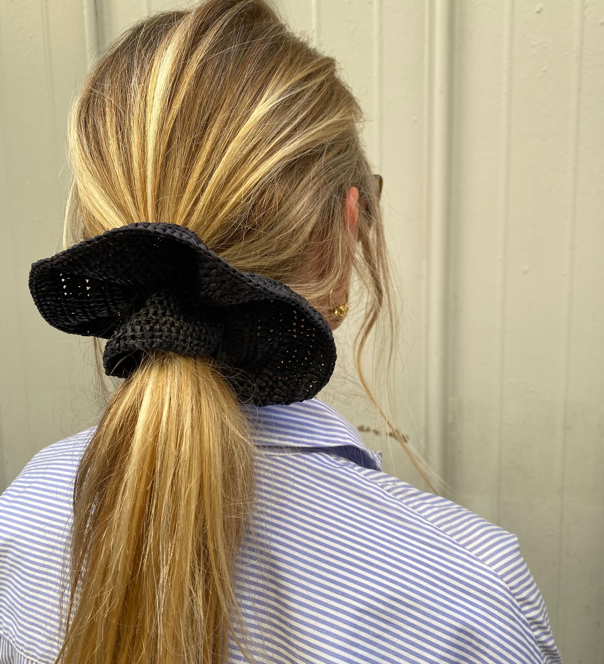 grand chouchou en crochet de raphia noir porté en queue de cheval 
