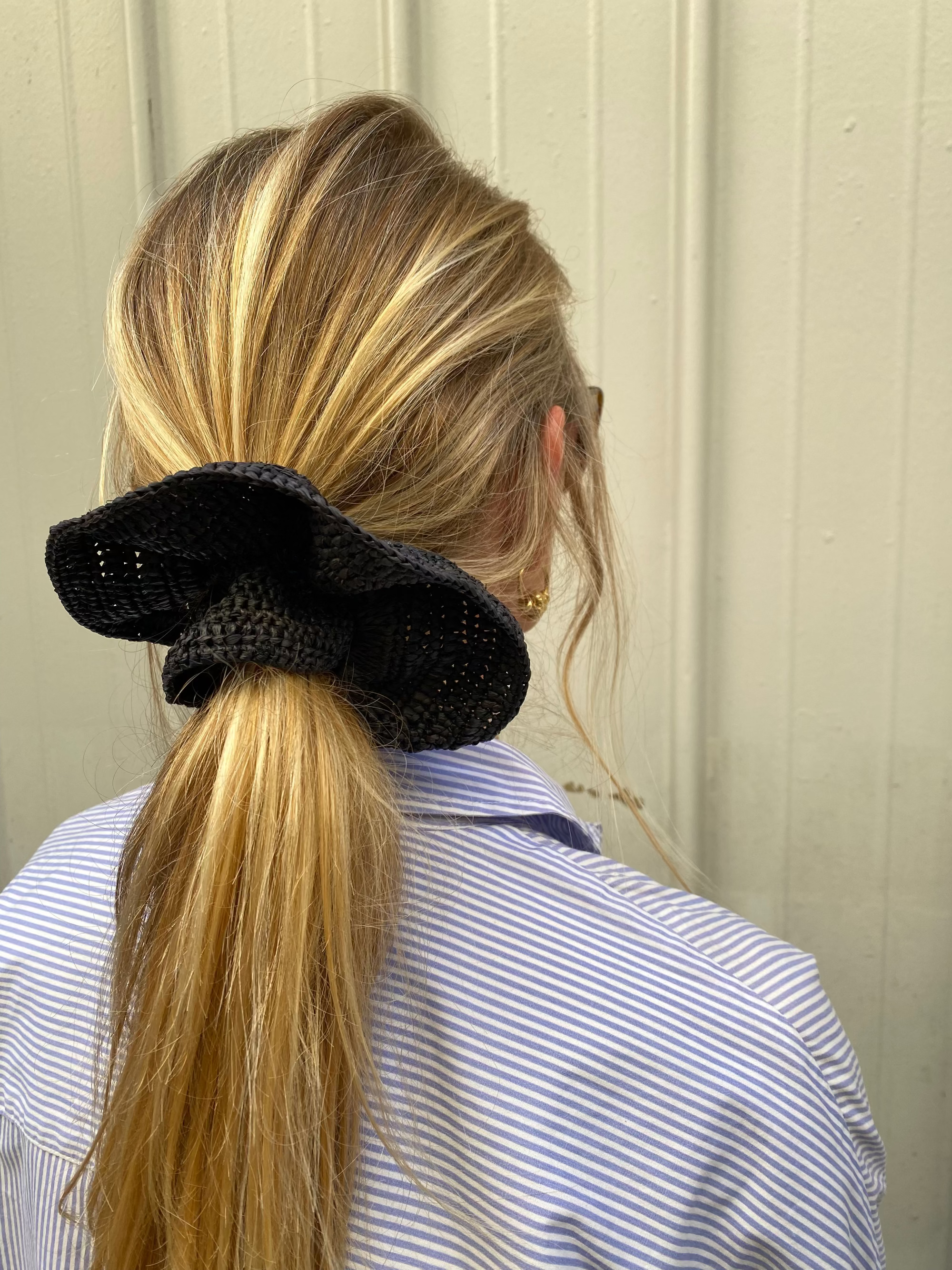 grand chouchou en crochet de raphia noir porté en queue de cheval 