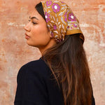petit foulard en coton caramel et violet porté dans les cheuveux