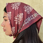 petit foulard en coton imprimé bordeaux porté sur la tête en fichu