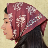 petit foulard en coton imprimé bordeaux porté sur la tête en fichu