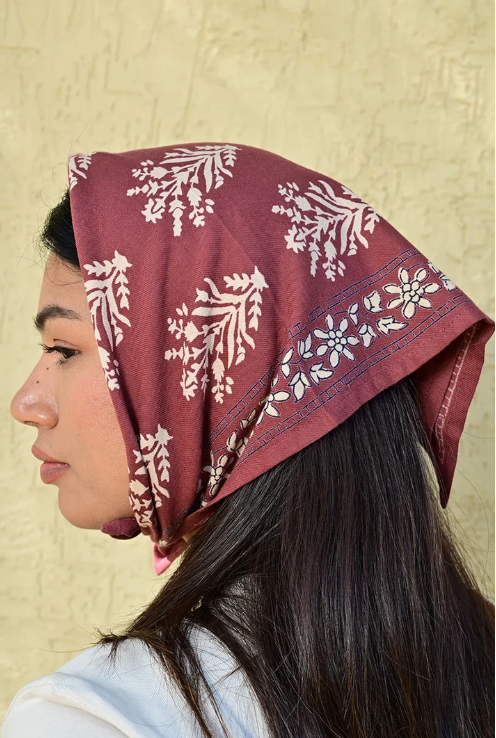 petit foulard en coton imprimé bordeaux porté sur la tête en fichu