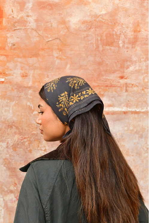 petit foulard en coton imprimé noir noué sur la tête 