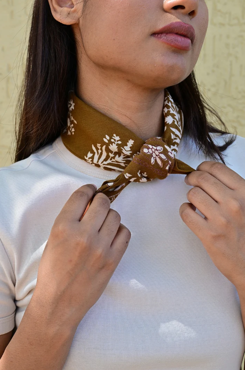 petit foulard en coton imprimé tabac noué autour du cou