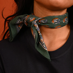 petit foulard vert en coton imprimé noué autour du cou