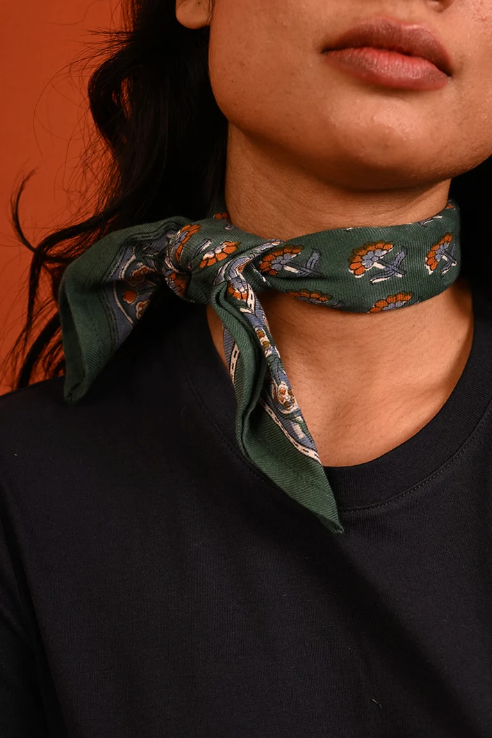 petit foulard vert en coton imprimé noué autour du cou