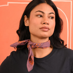 petit foulard en coton imprimé violet noué autour du cou