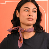 petit foulard en coton imprimé violet noué autour du cou