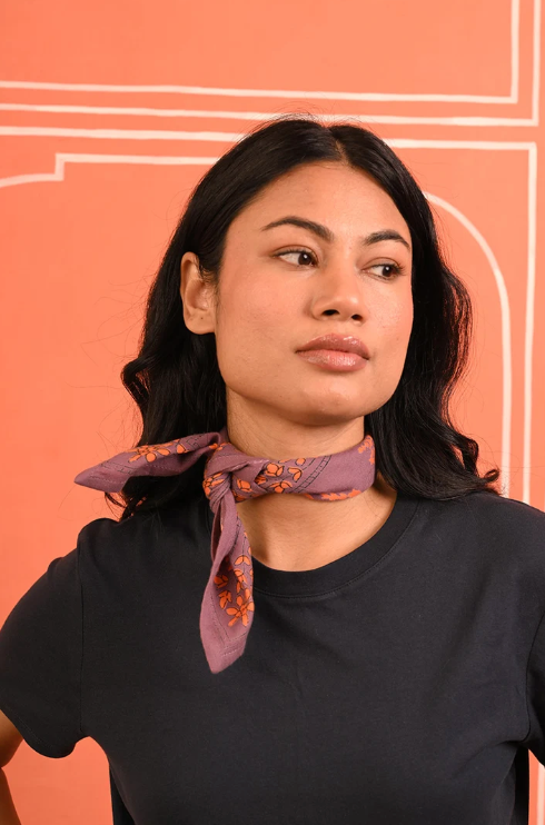 petit foulard en coton imprimé violet noué autour du cou