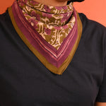 petit foulard en coton kaki avec motif floral violet porté comme un bandana