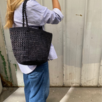 sac cabas en raphia noir ajouré porté à l'épaule