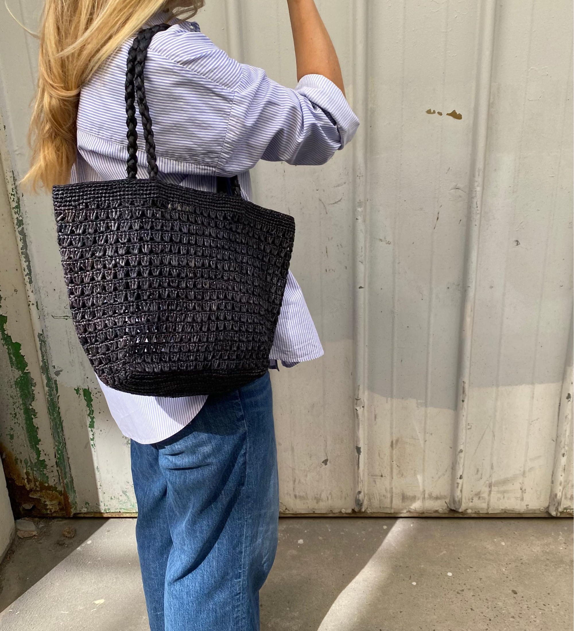 sac cabas en raphia noir ajouré porté à l'épaule