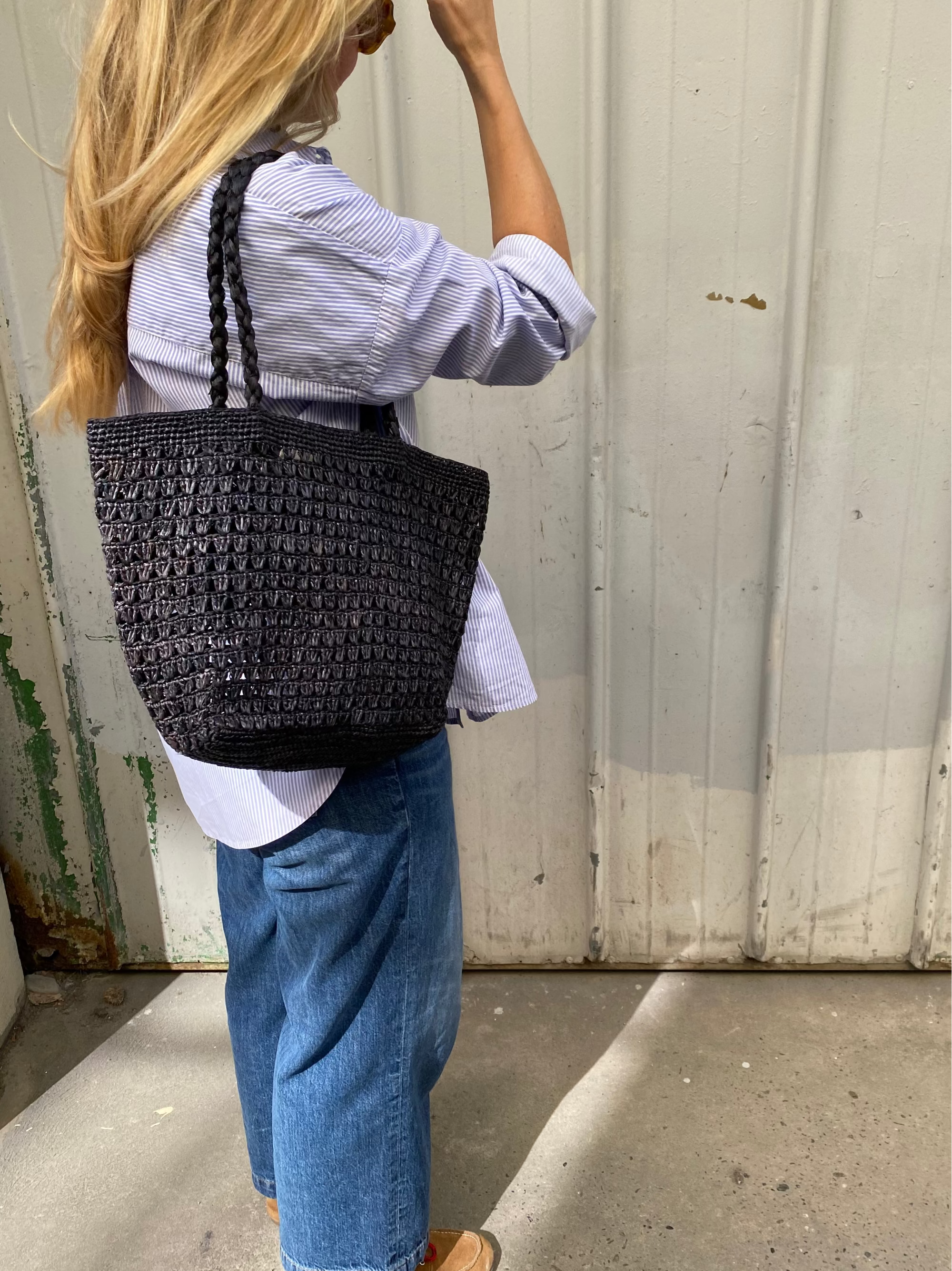 sac cabas en raphia noir ajouré porté à l'épaule