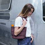 sac cabas en crochet de raphia chocolat porté à l'épaule en ville