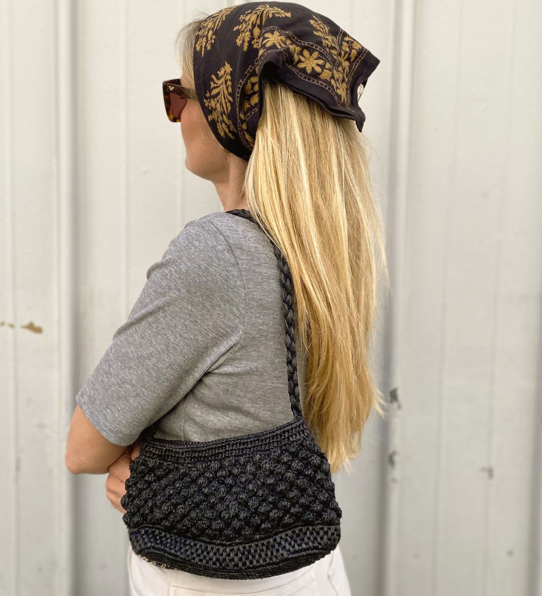 Petit sac en raphia noir porté à l’épaule, élégant et minimal