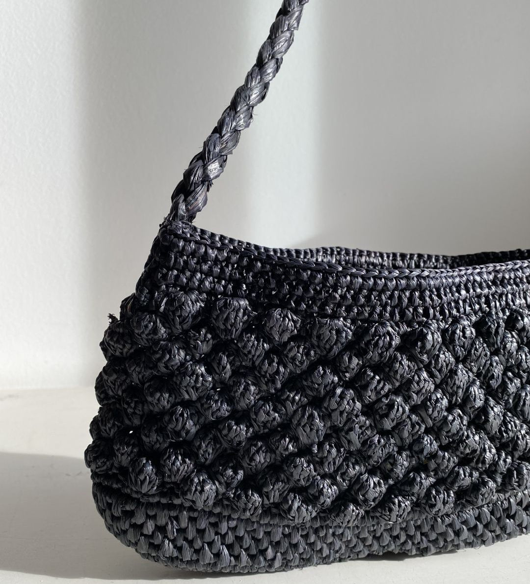 Petit sac en raphia noir vu de côté, format baguette structuré- BAO noir
