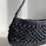 Petit sac en raphia noir vu de côté, format baguette structuré- BAO noir