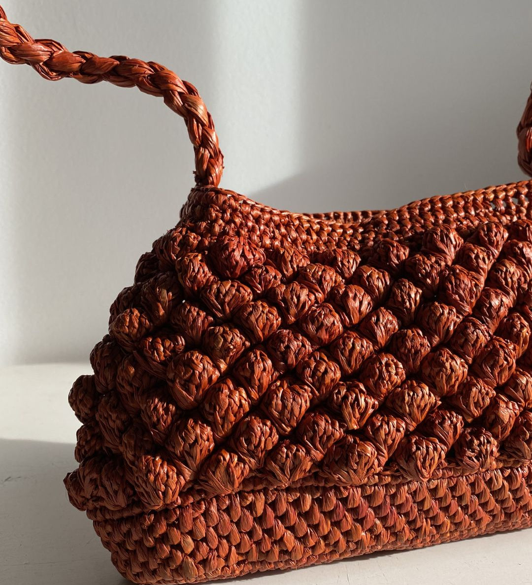 Petit sac en raphia rouille vu de côté, format baguette