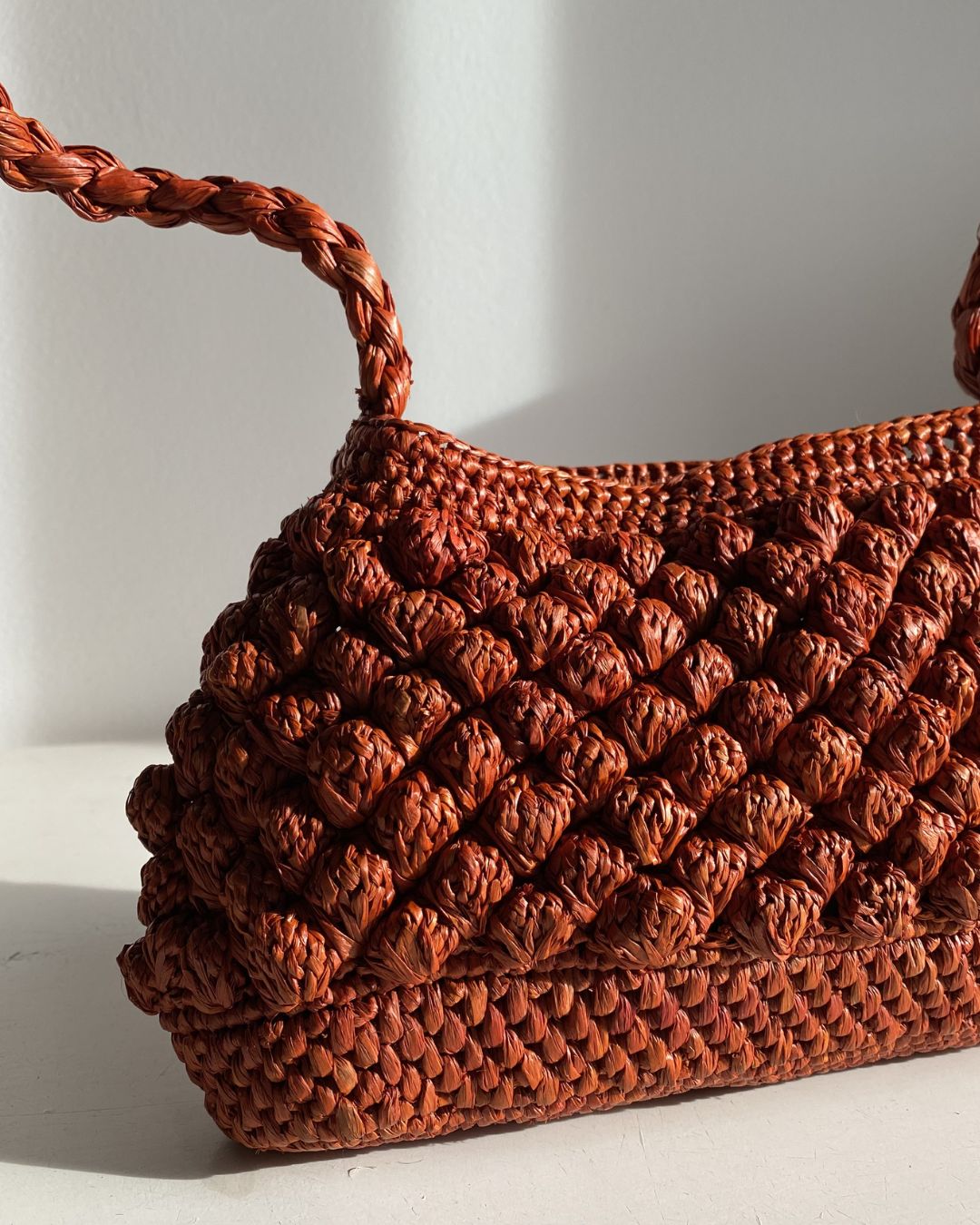 Petit sac en raphia rouille vu de côté, format baguette