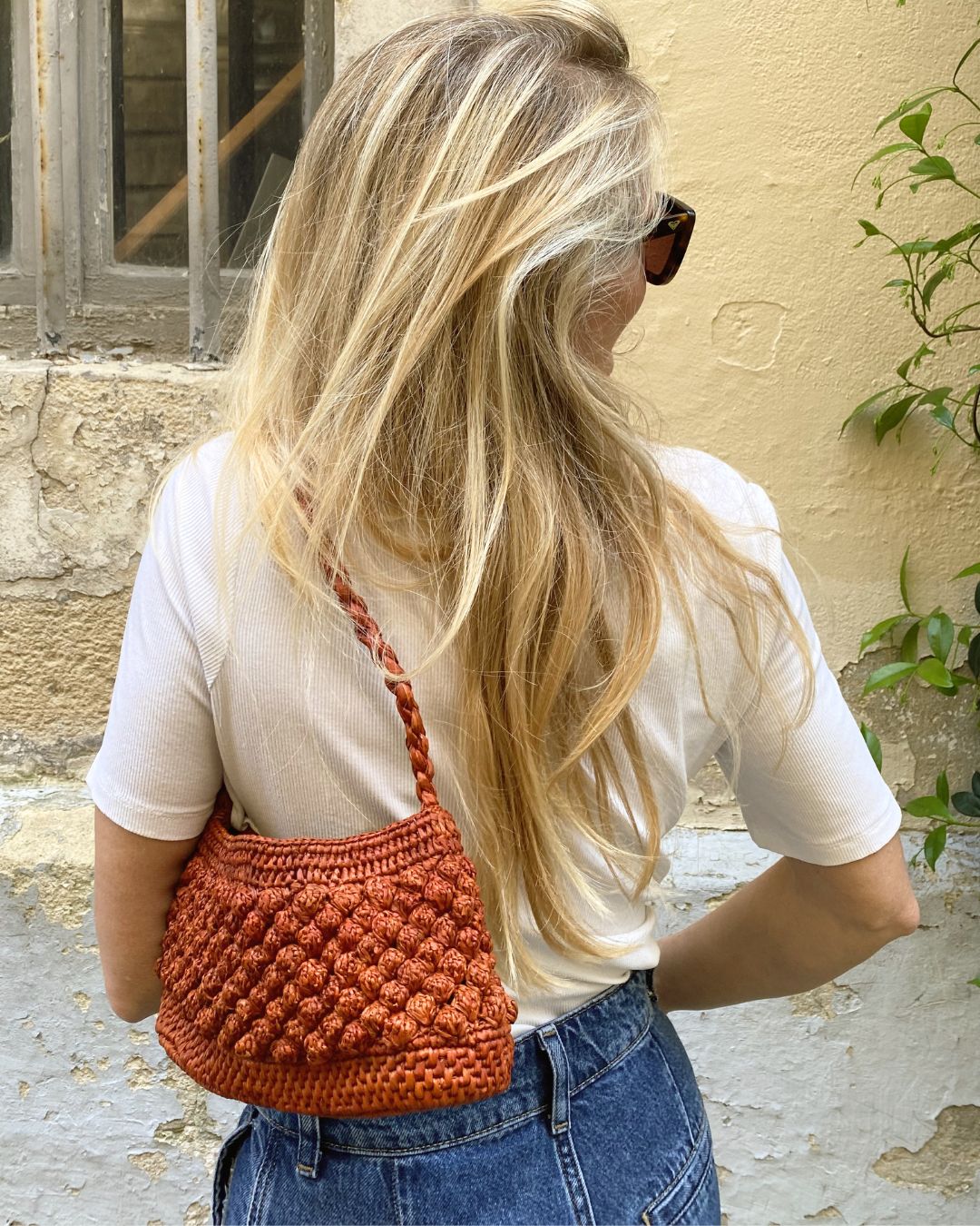 Petit sac en raphia rouille porté à l’épaule, léger et naturel