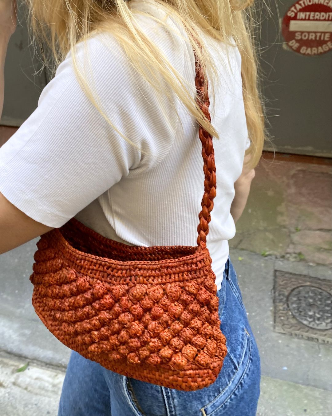 Petit sac en raphia rouille porté vue de profil