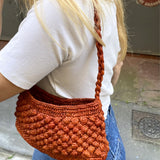 Petit sac en raphia rouille porté vue de profil