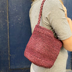 petit sac seau en raphia bordeaux fait main porté à l'épaule, compact et léger
