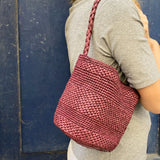 petit sac seau en raphia bordeaux fait main porté à l'épaule, compact et léger