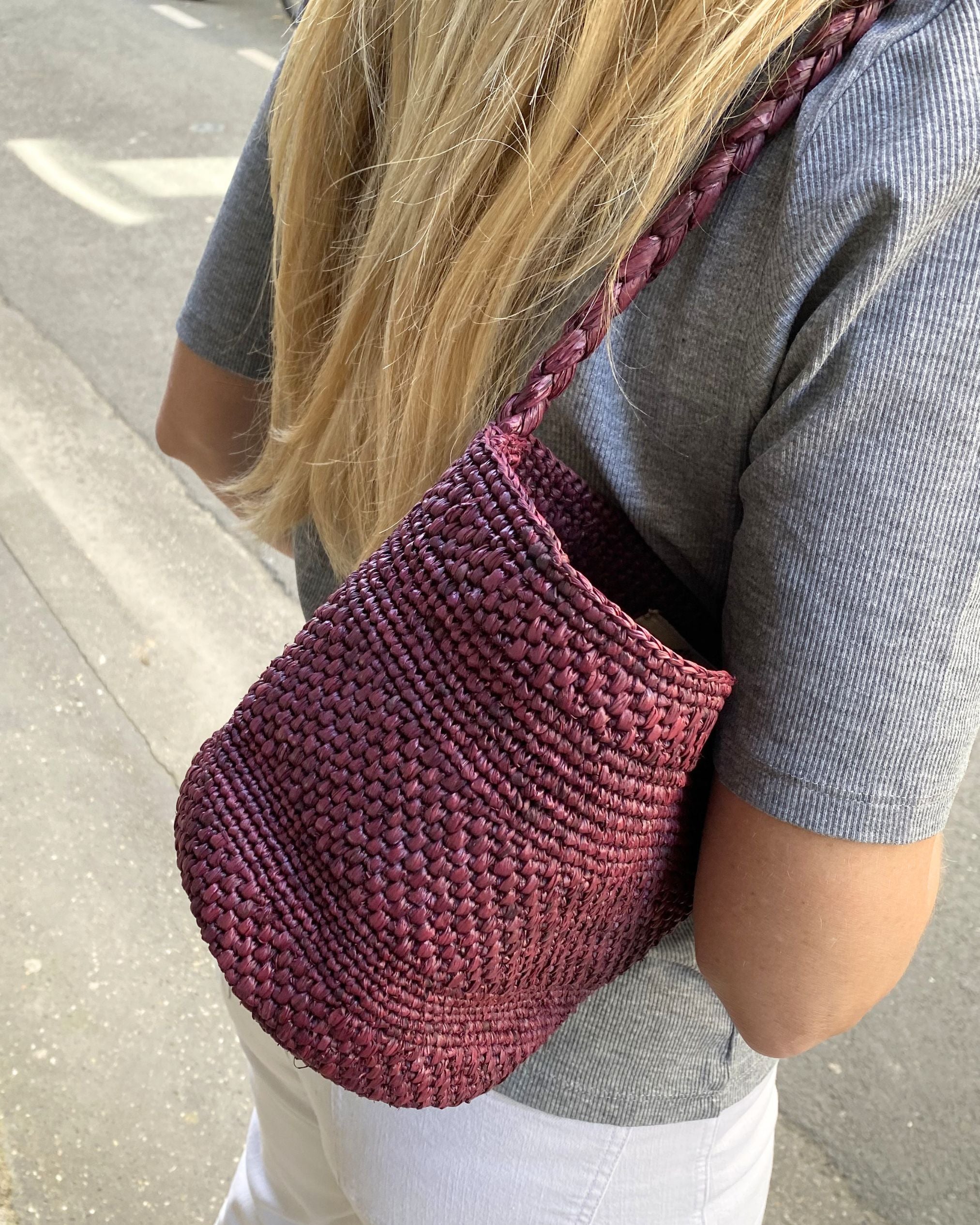 zoom sur le crochet de raphia du petit sac seau bordeaux, élégant 