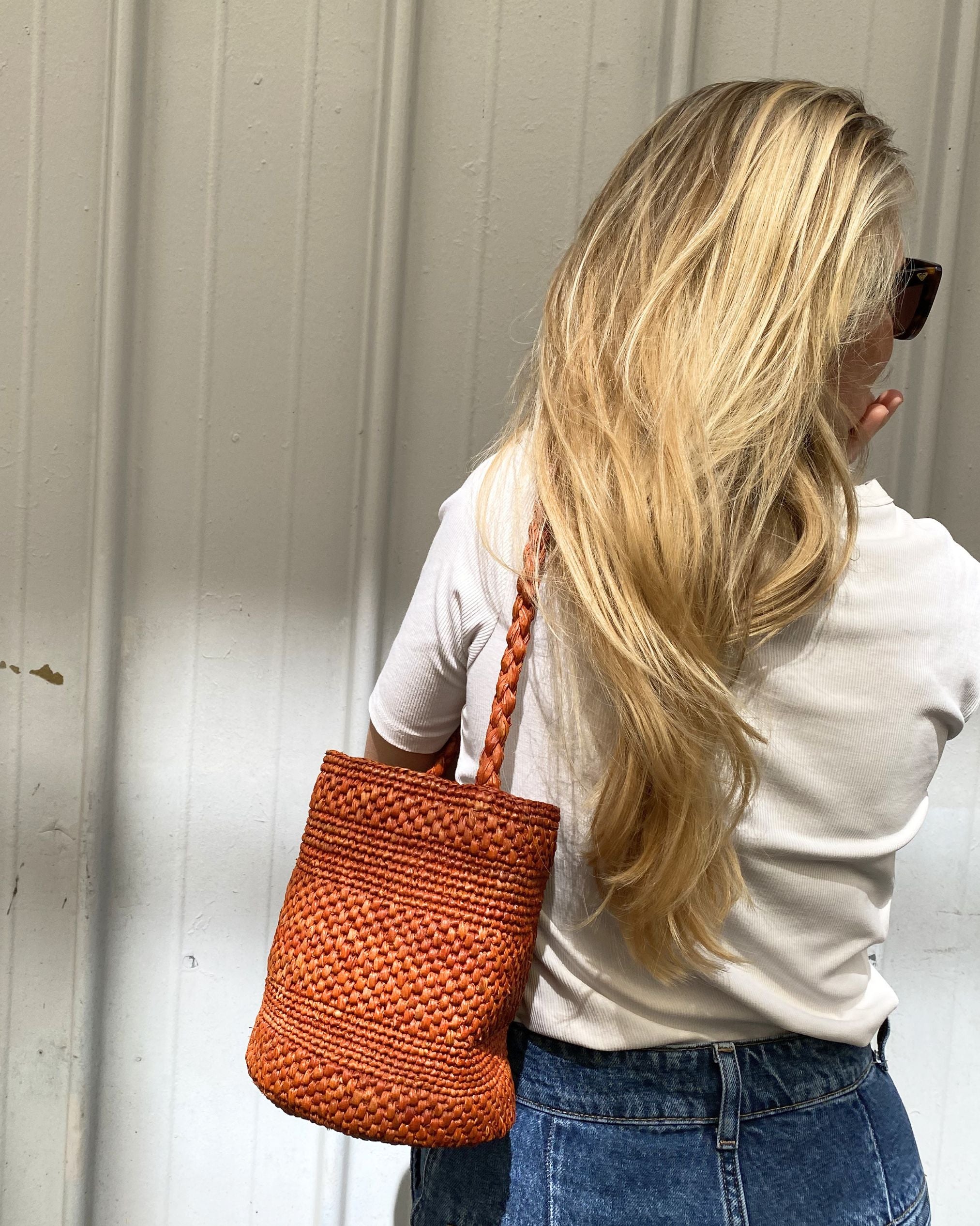 Petit sac en raphia rouille porté à l’épaule, léger et naturel