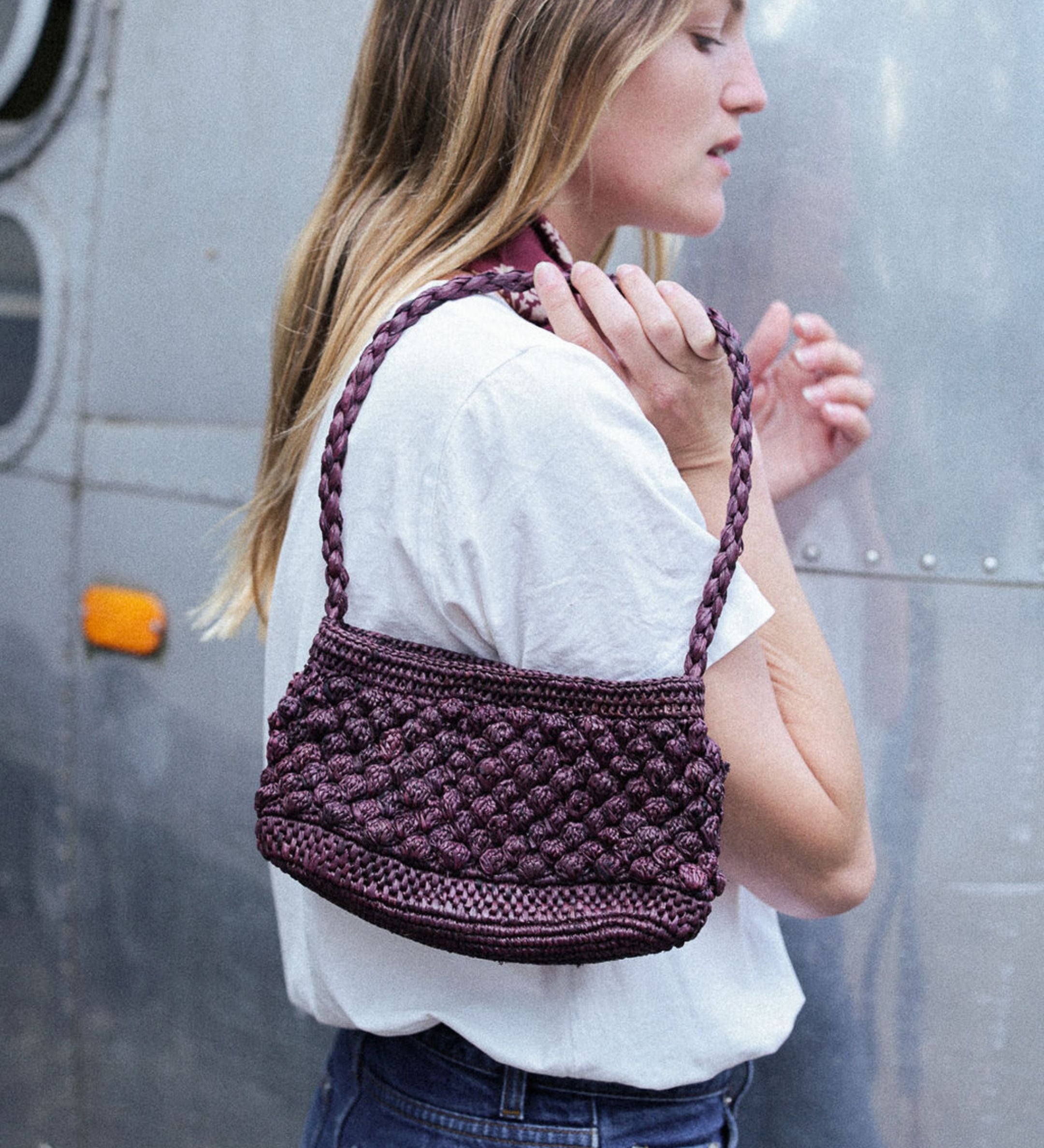 petit sac baguette chocolat en raphia boules porté avec une tenue déocntractée