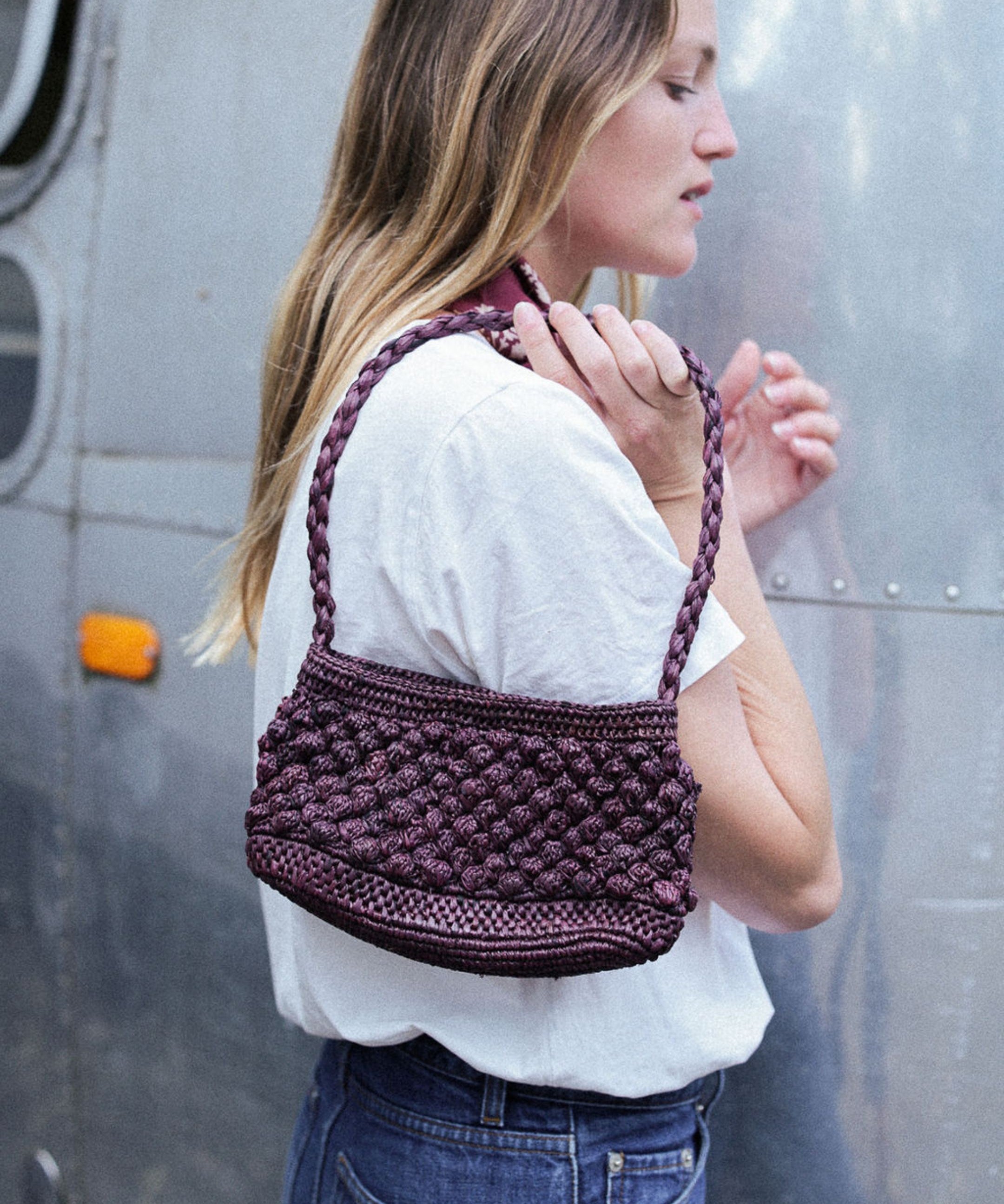 petit sac baguette chocolat en raphia boules porté avec une tenue déocntractée