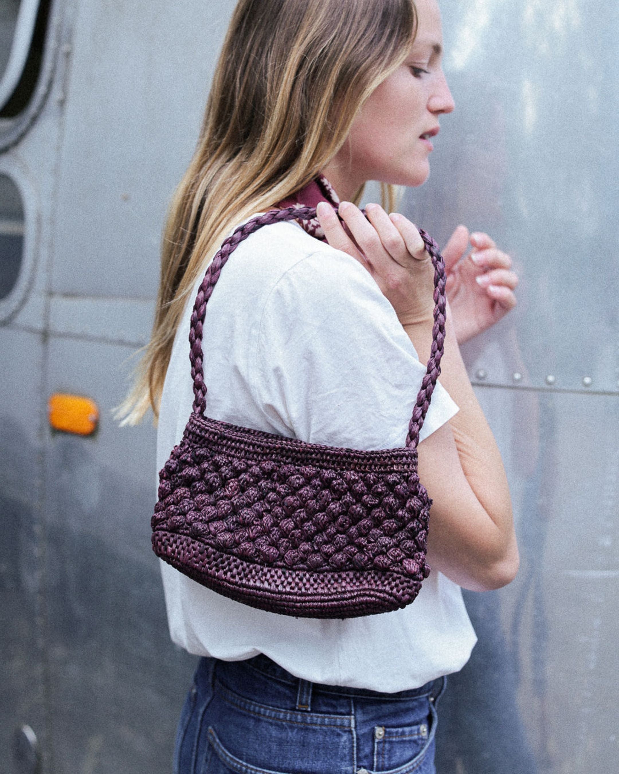 petit sac baguette chocolat en raphia boules porté avec une tenue déocntractée
