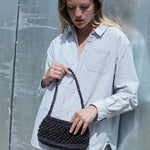 petit sac baguette noir en raphia boules porté avec une tenue de ville