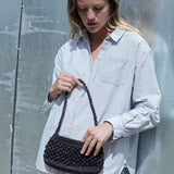 petit sac baguette noir en raphia boules porté avec une tenue de ville