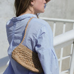 petit sac baguette en raphia thé porté à l'épaule 